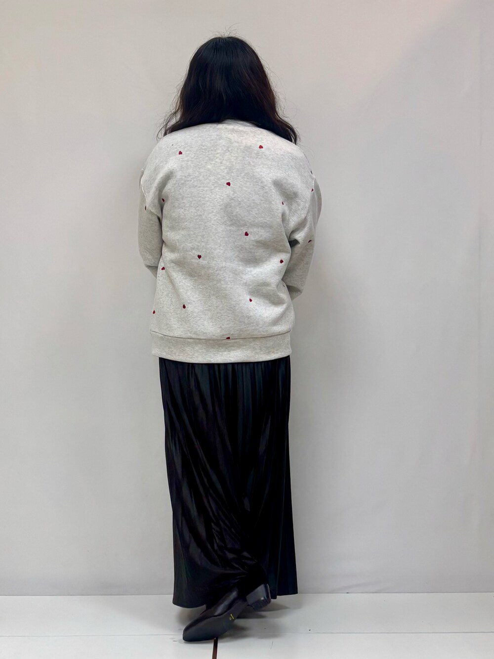 グレー系のスウェット、ベージュ系のスカート、ブラック系のブーツを着用したレディースの冬コーディネートの3枚目の写真