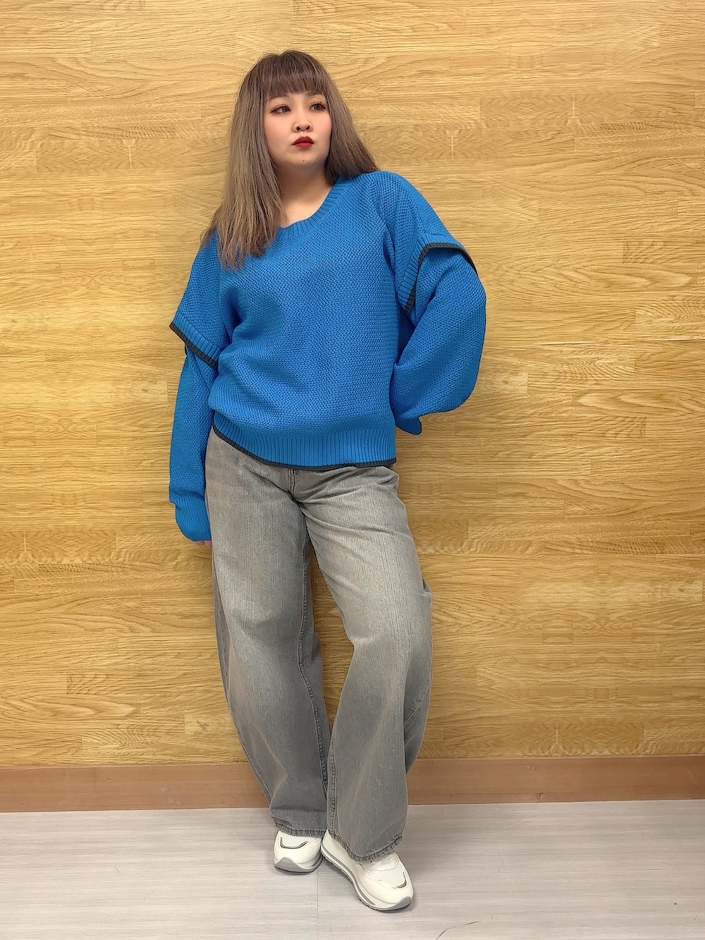 ブルー系のニット/セーター、グレー系のデニムパンツ、ホワイト系のスニーカーを着用したレディースの冬コーディネートの2枚目の写真