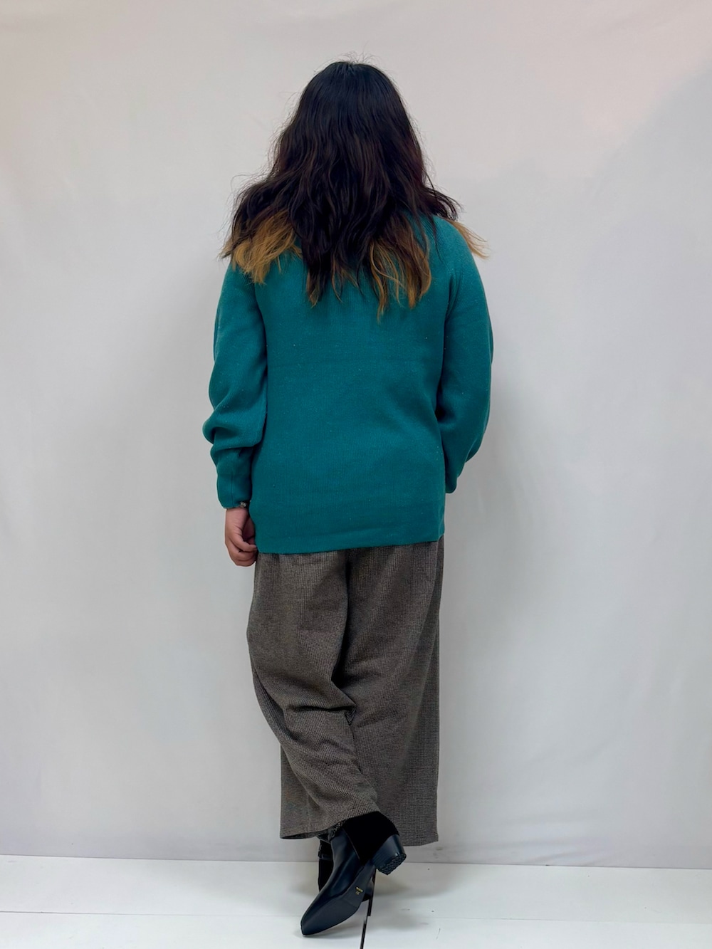 グレー系のその他パンツ、グリーン系のニット/セーターを着用したレディースの冬コーディネートの3枚目の写真