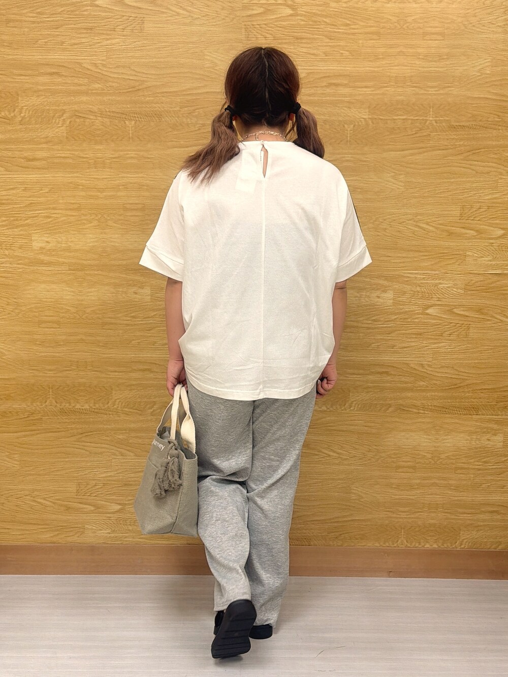 ブラック系のTシャツ/カットソー、グレー系のその他パンツ、グレー系のトートバッグを着用したレディースの春コーディネートの3枚目の写真