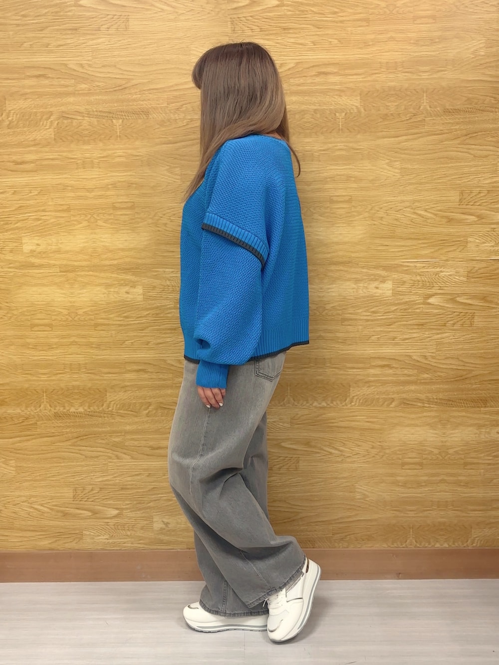 ブルー系のニット/セーター、グレー系のデニムパンツ、ホワイト系のスニーカーを着用したレディースの冬コーディネートの3枚目の写真