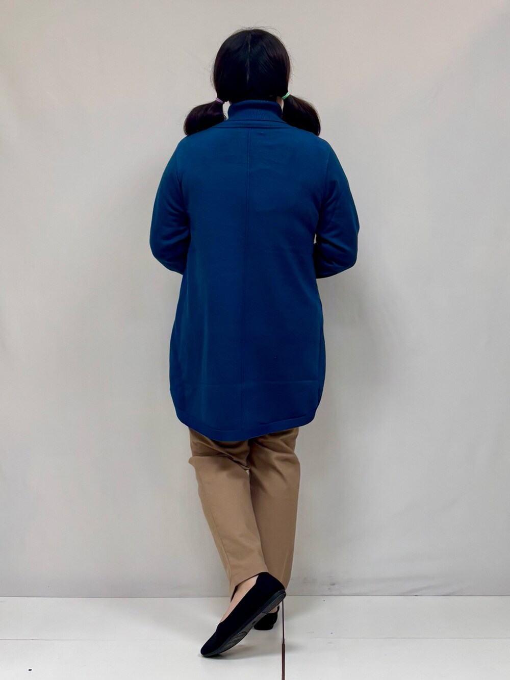 ブルー系のチュニック、ブラック系のパンプス、ブラウン系のその他パンツを着用したレディースの冬コーディネートの3枚目の写真