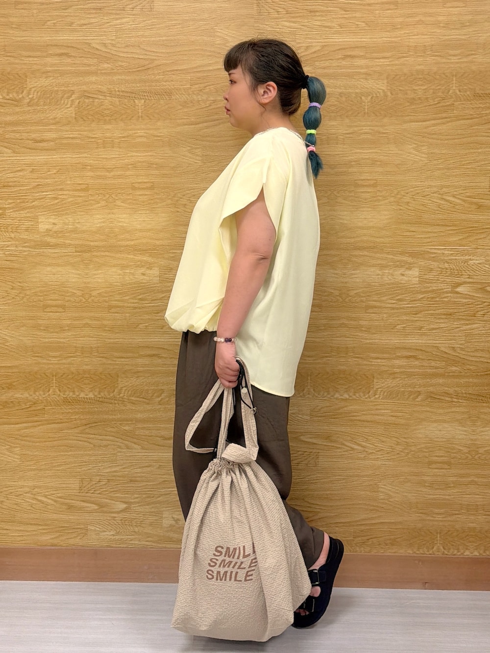 イエロー系のTシャツ/カットソー、グリーン系のその他パンツ、ブラック系のサンダルを着用したレディースの夏コーディネートの2枚目の写真