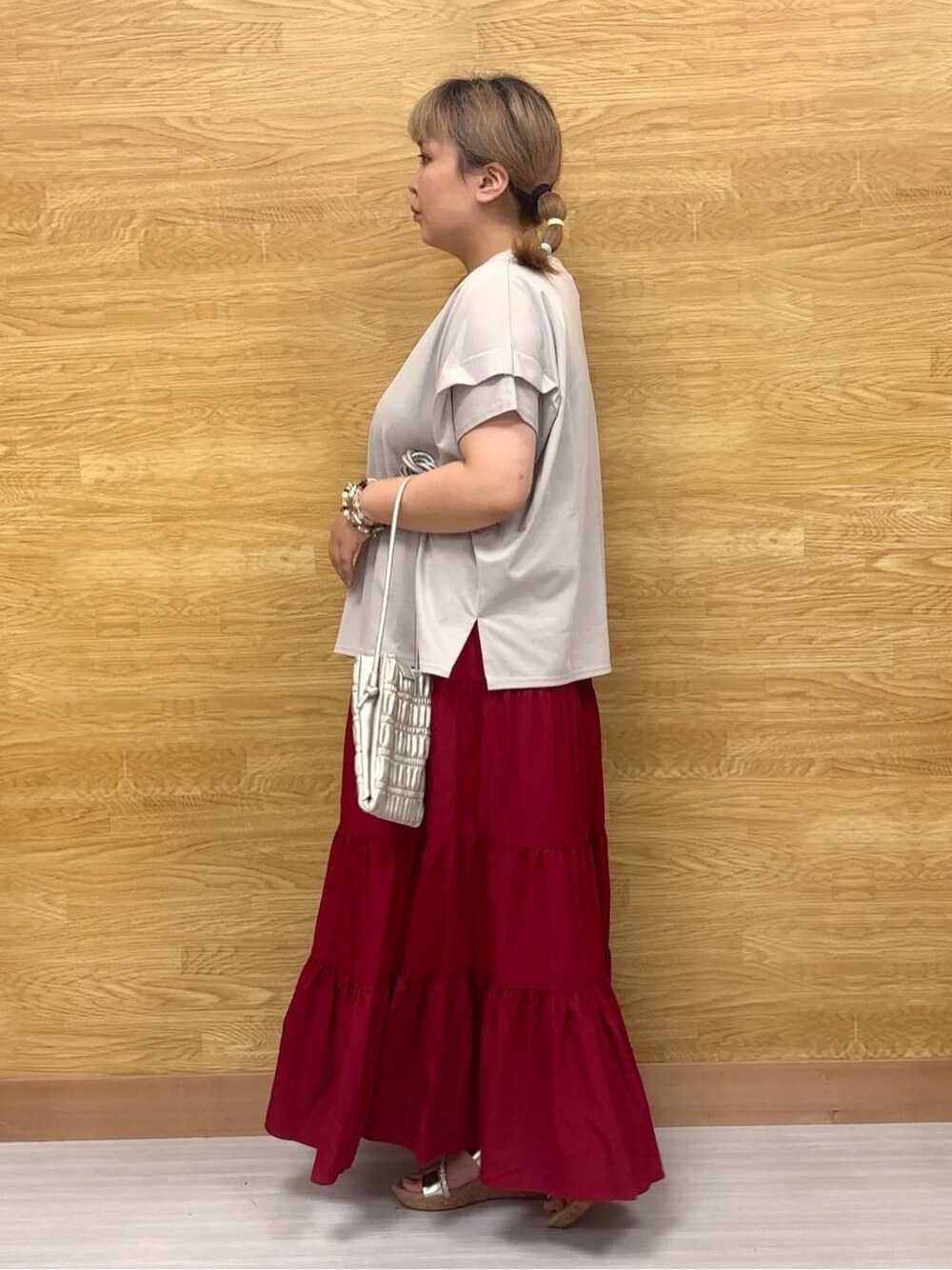 グレー系のTシャツ/カットソー、レッド系のスカート、シルバー系のサンダルを着用したレディースの夏コーディネートの2枚目の写真