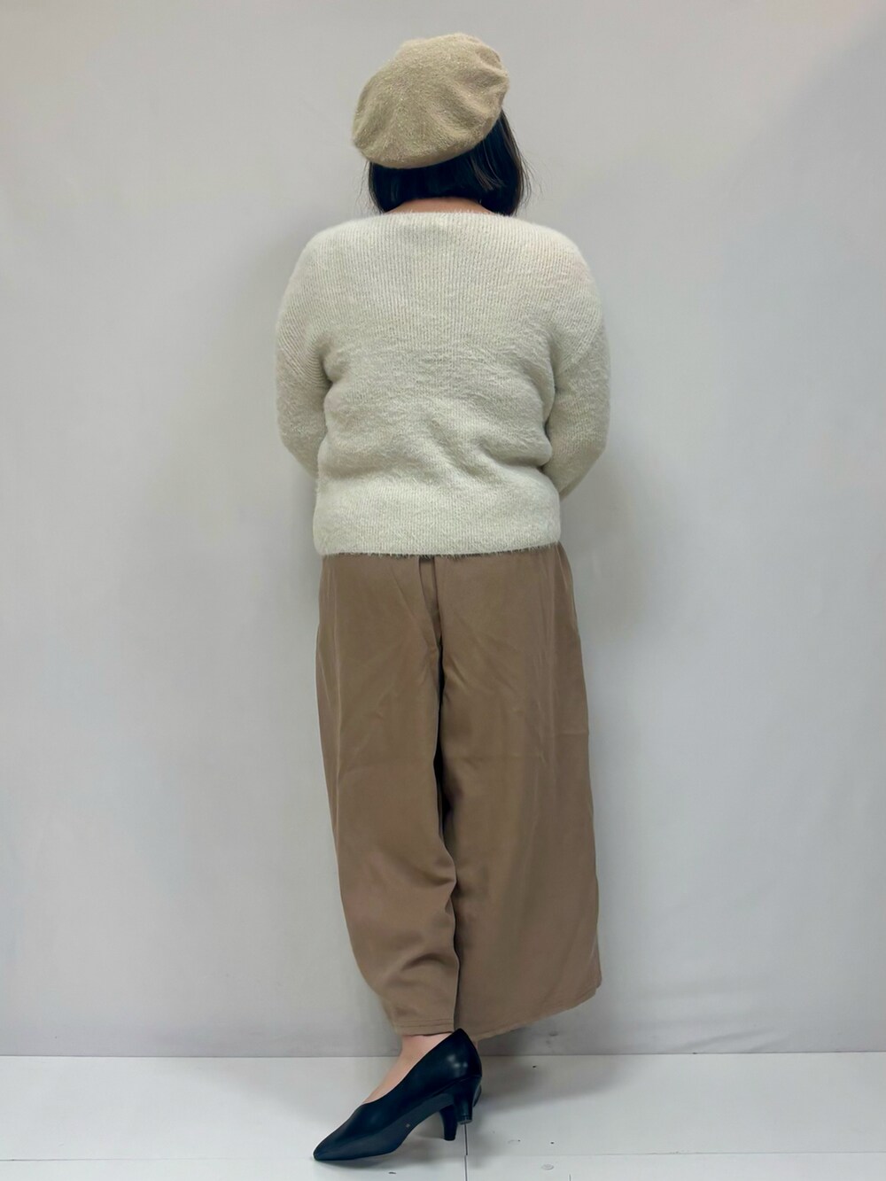 ホワイト系のニット/セーター、ベージュ系のその他パンツ、ブラック系のパンプスを着用したレディースの冬コーディネートの3枚目の写真