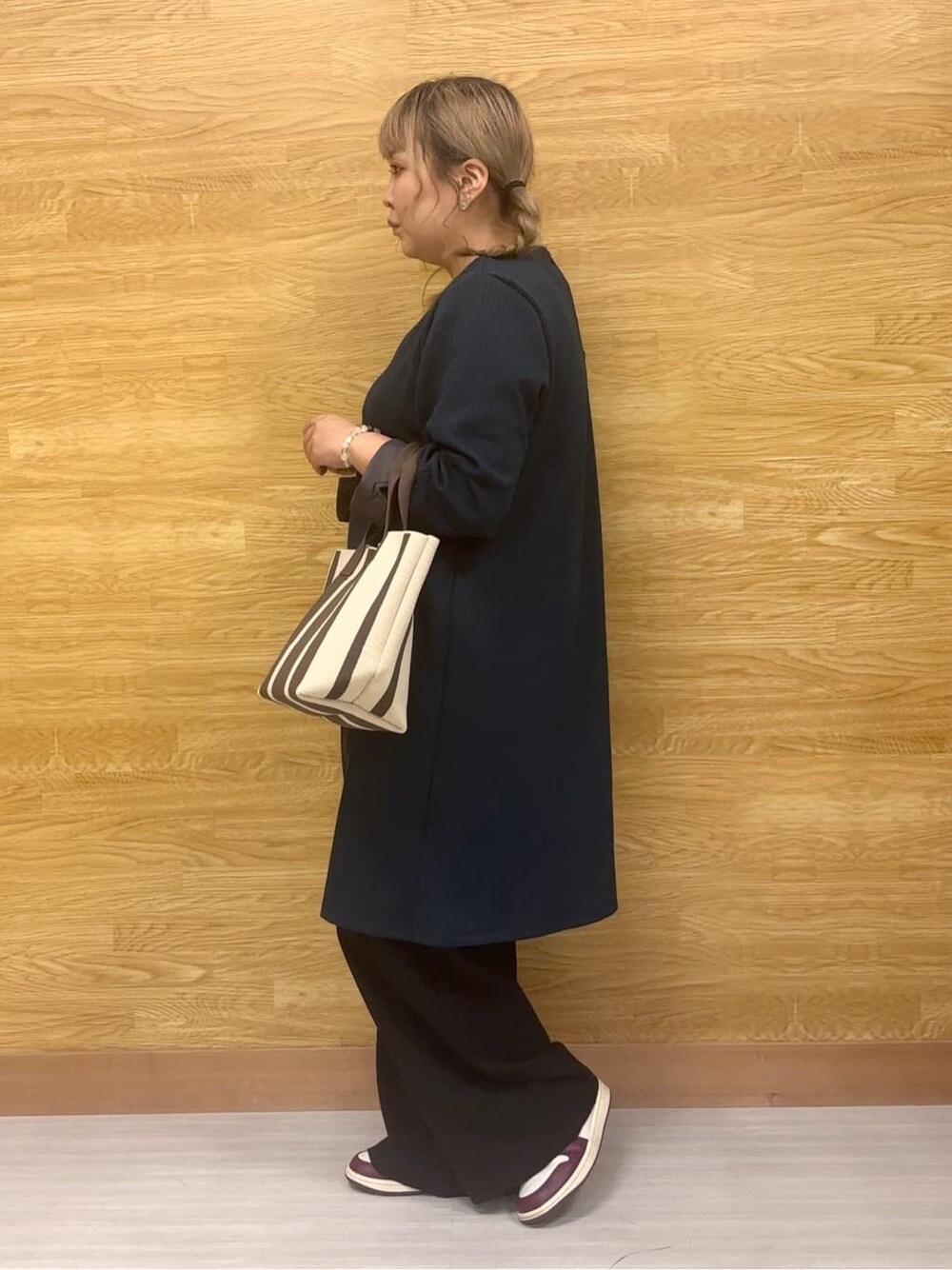 グリーン系のチュニック、ブラック系のその他パンツ、ブラウン系のトートバッグを着用したレディースの秋コーディネートの2枚目の写真