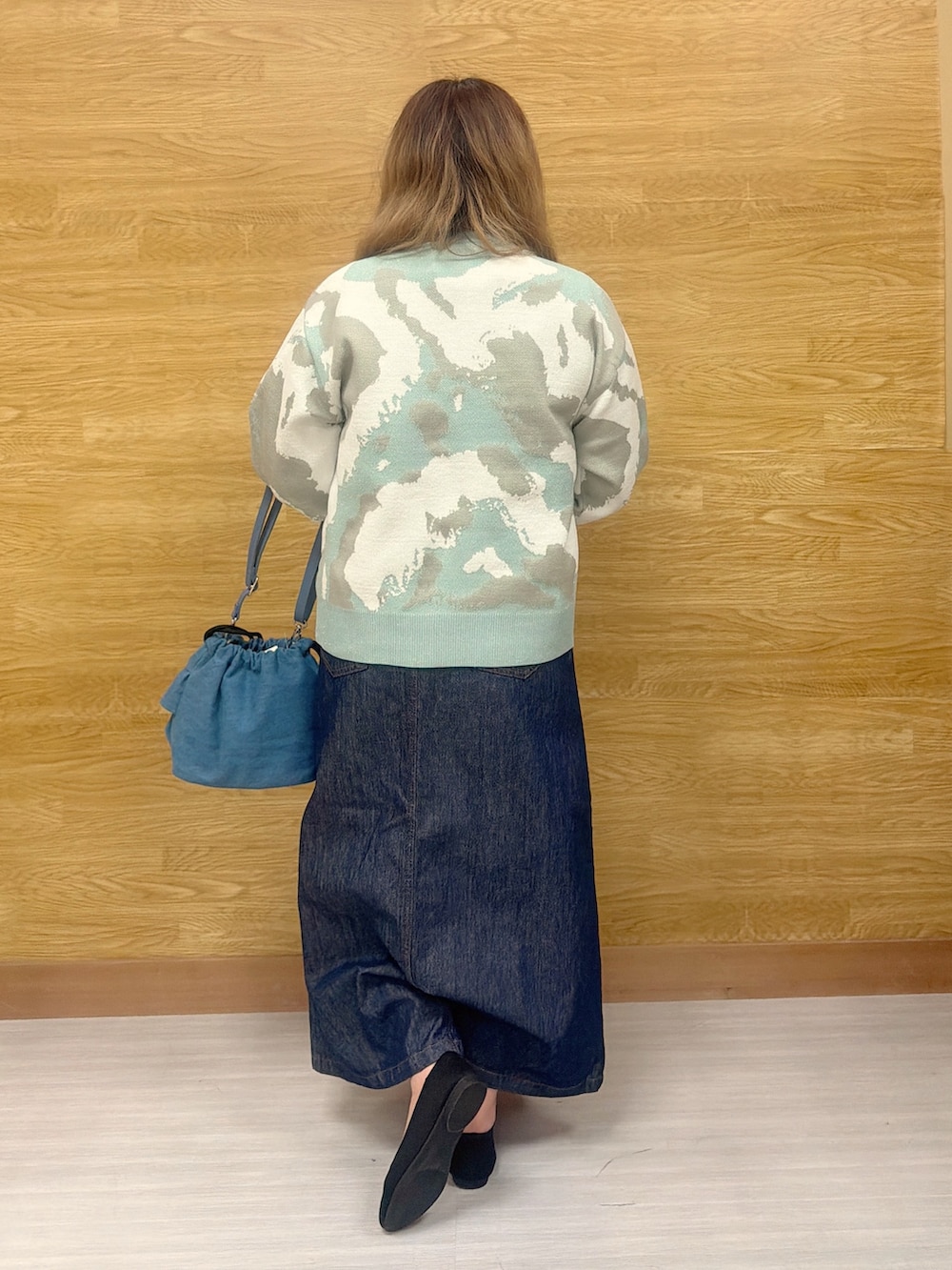 ブルー系のデニムスカート、グリーン系のニット/セーターを着用したレディースの春コーディネートの3枚目の写真