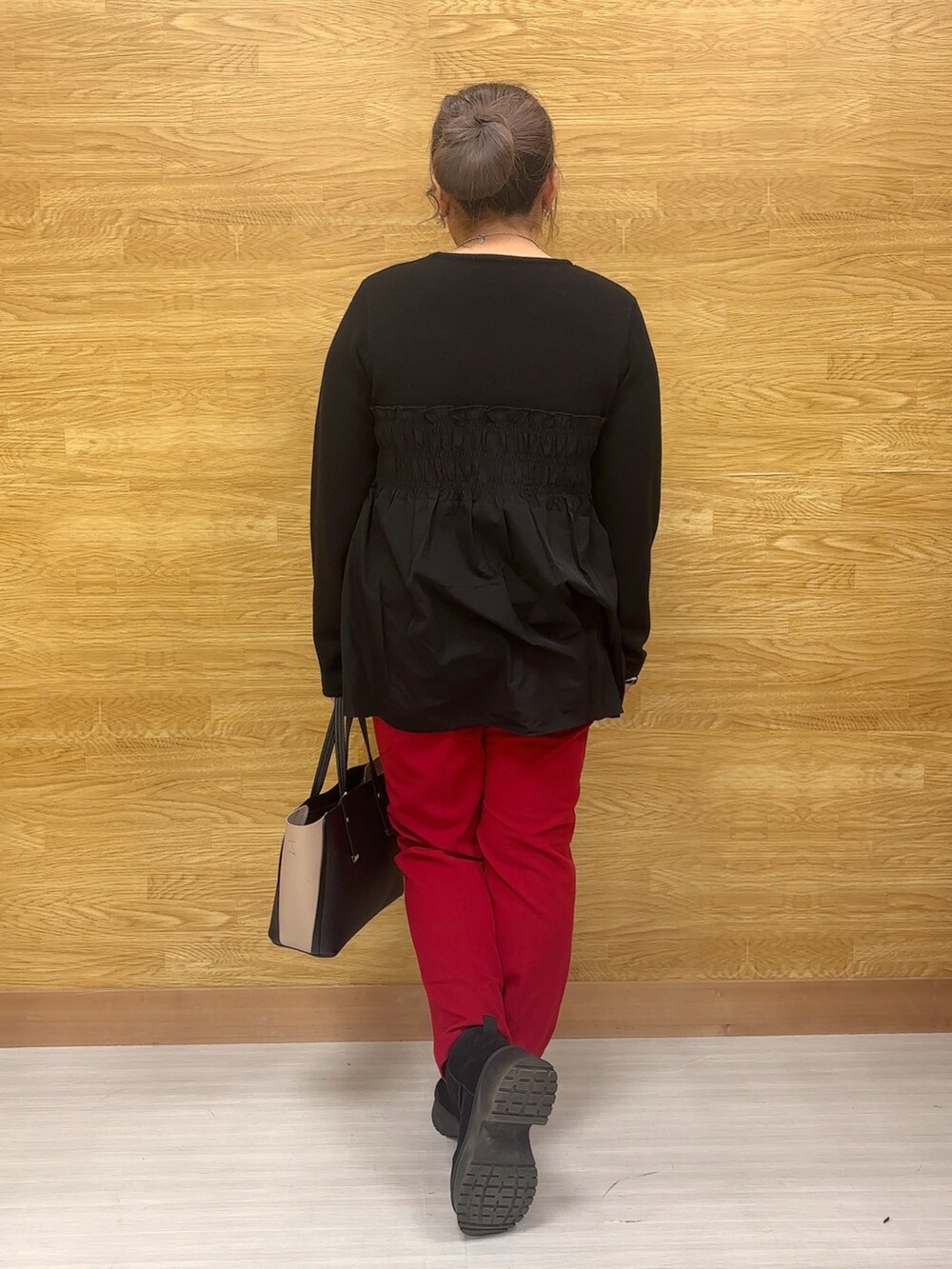 ブラック系のチュニック、レッド系のその他パンツを着用したレディースの冬コーディネートの3枚目の写真