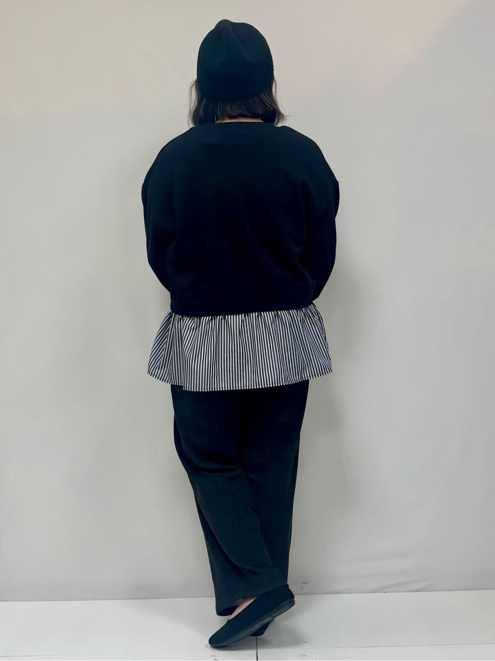 ブラック系のスウェット、ブラック系のその他パンツ、ブラック系のパンプスを着用したレディースの冬コーディネートの3枚目の写真