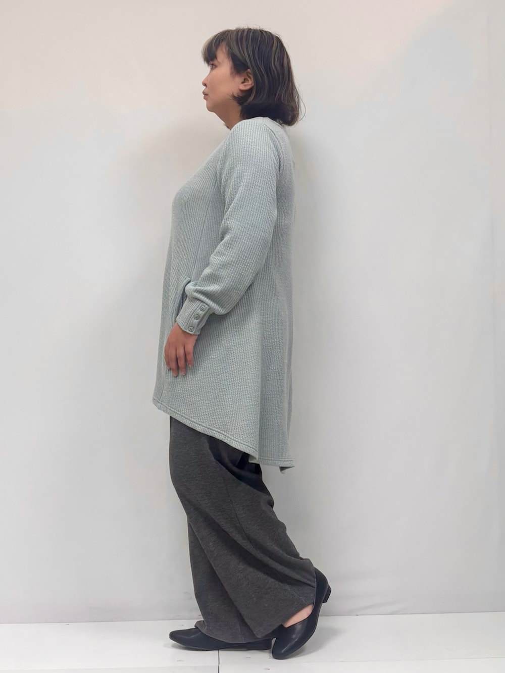 グリーン系のチュニック、グレー系のその他パンツを着用したレディースの春コーディネートの2枚目の写真