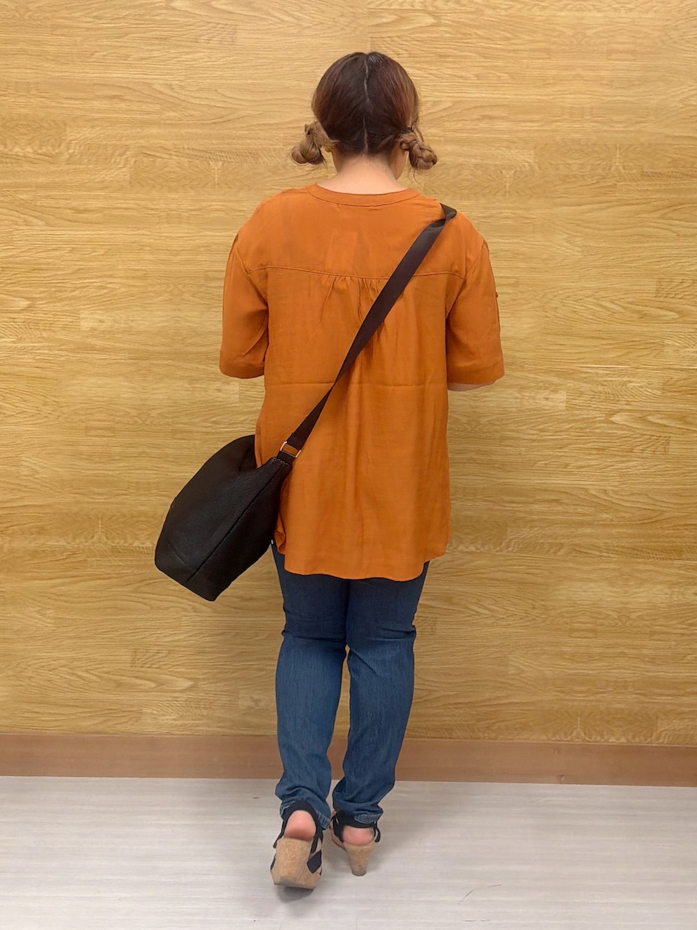 オレンジ系のシャツ/ブラウス、ブルー系のデニムパンツ、ブラック系のショルダーバッグを着用したレディースの夏コーディネートの3枚目の写真
