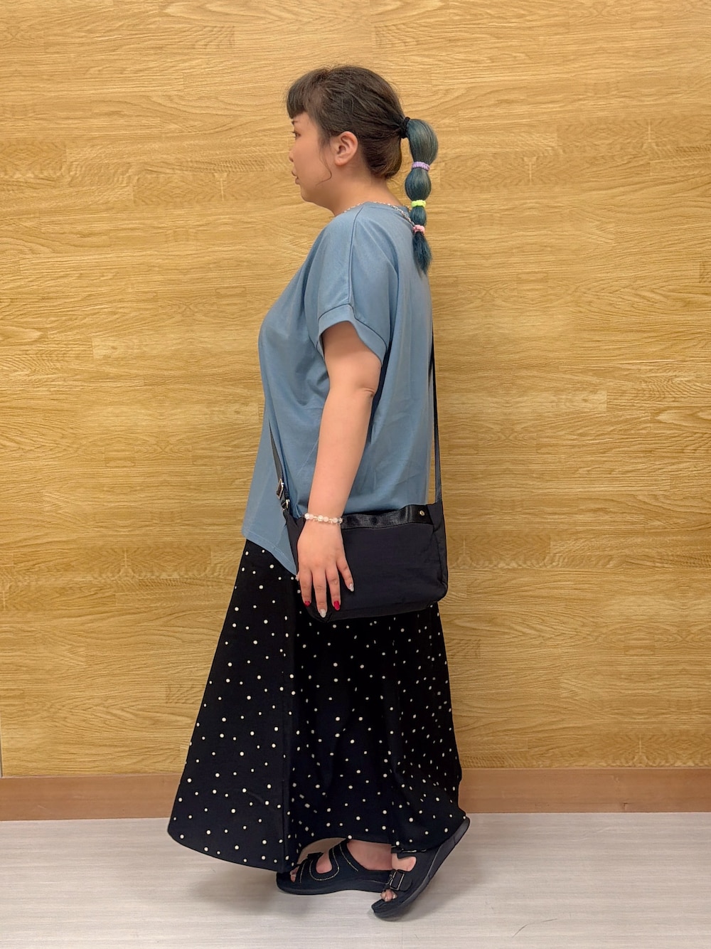 ブルー系のTシャツ/カットソー、ブラック系のスカート、ブラック系のサンダルを着用したレディースの夏コーディネートの2枚目の写真