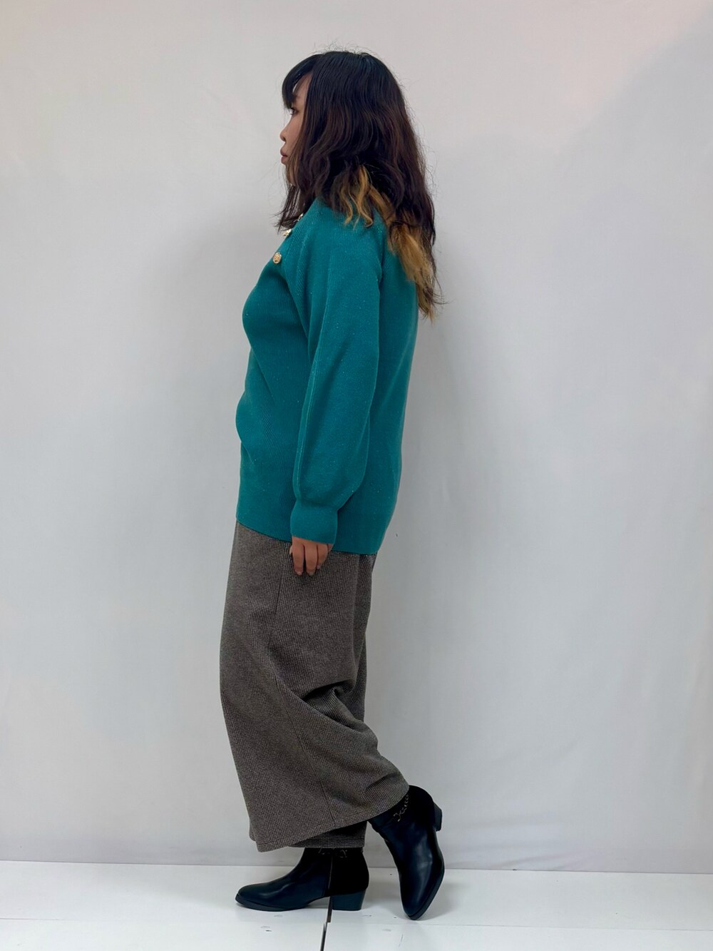 グレー系のその他パンツ、グリーン系のニット/セーターを着用したレディースの冬コーディネートの2枚目の写真