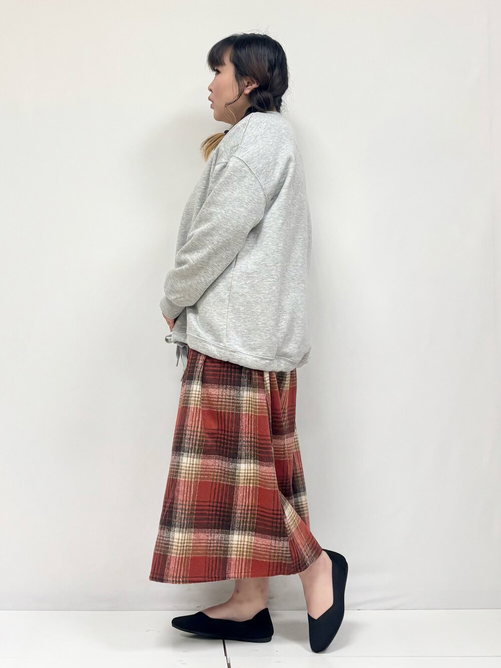 ベージュ系のスカート、ブラック系のパンプス、グレー系のTシャツ/カットソーを着用したレディースの冬コーディネートの2枚目の写真