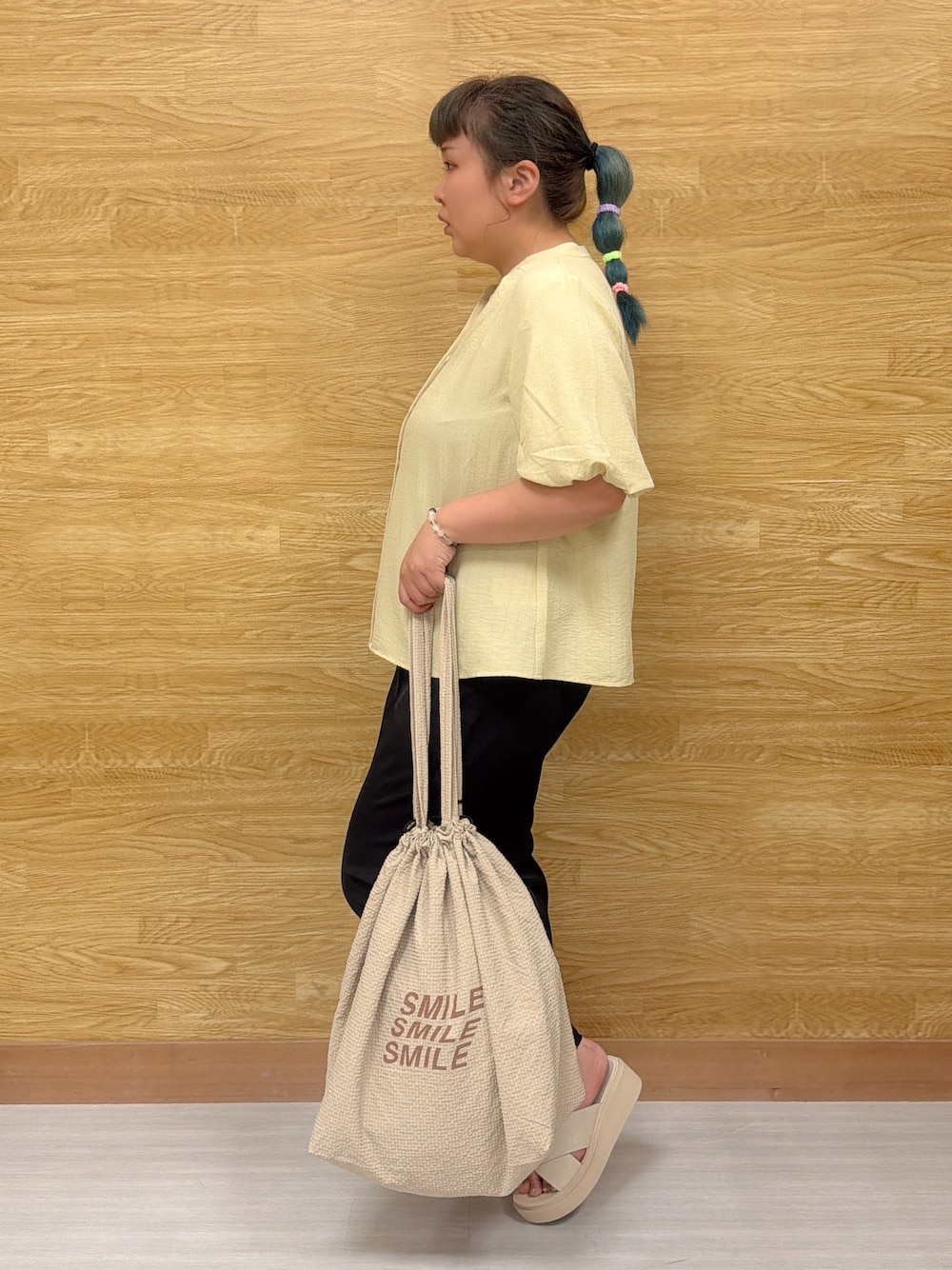 イエロー系のシャツ/ブラウス、ブラック系のその他パンツ、ベージュ系のサンダルを着用したレディースの夏コーディネートの2枚目の写真