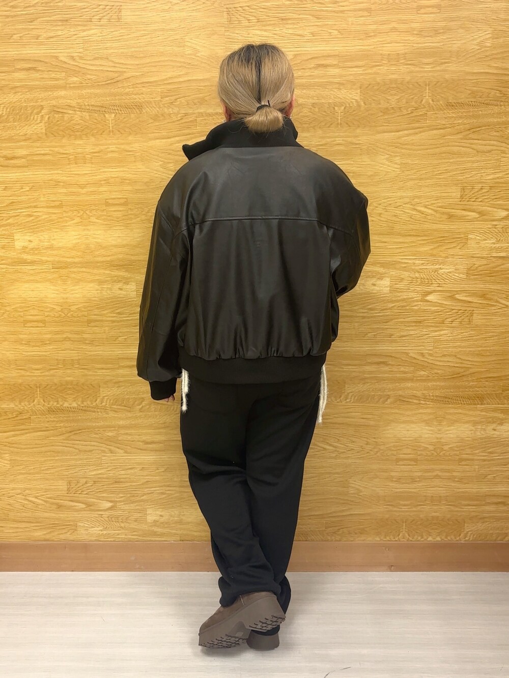 ブラック系のブルゾン、ホワイト系のニット/セーター、ブラック系のその他パンツを着用したレディースの秋コーディネートの2枚目の写真