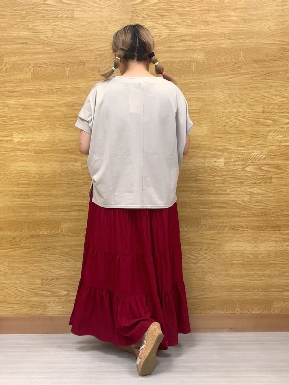 グレー系のTシャツ/カットソー、レッド系のスカート、シルバー系のサンダルを着用したレディースの夏コーディネートの3枚目の写真