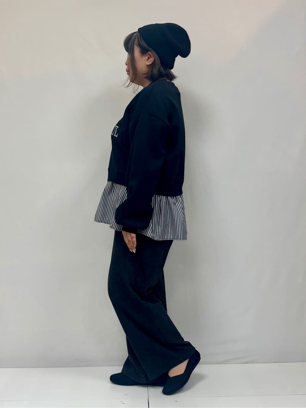 ブラック系のスウェット、ブラック系のその他パンツ、ブラック系のパンプスを着用したレディースの冬コーディネートの2枚目の写真