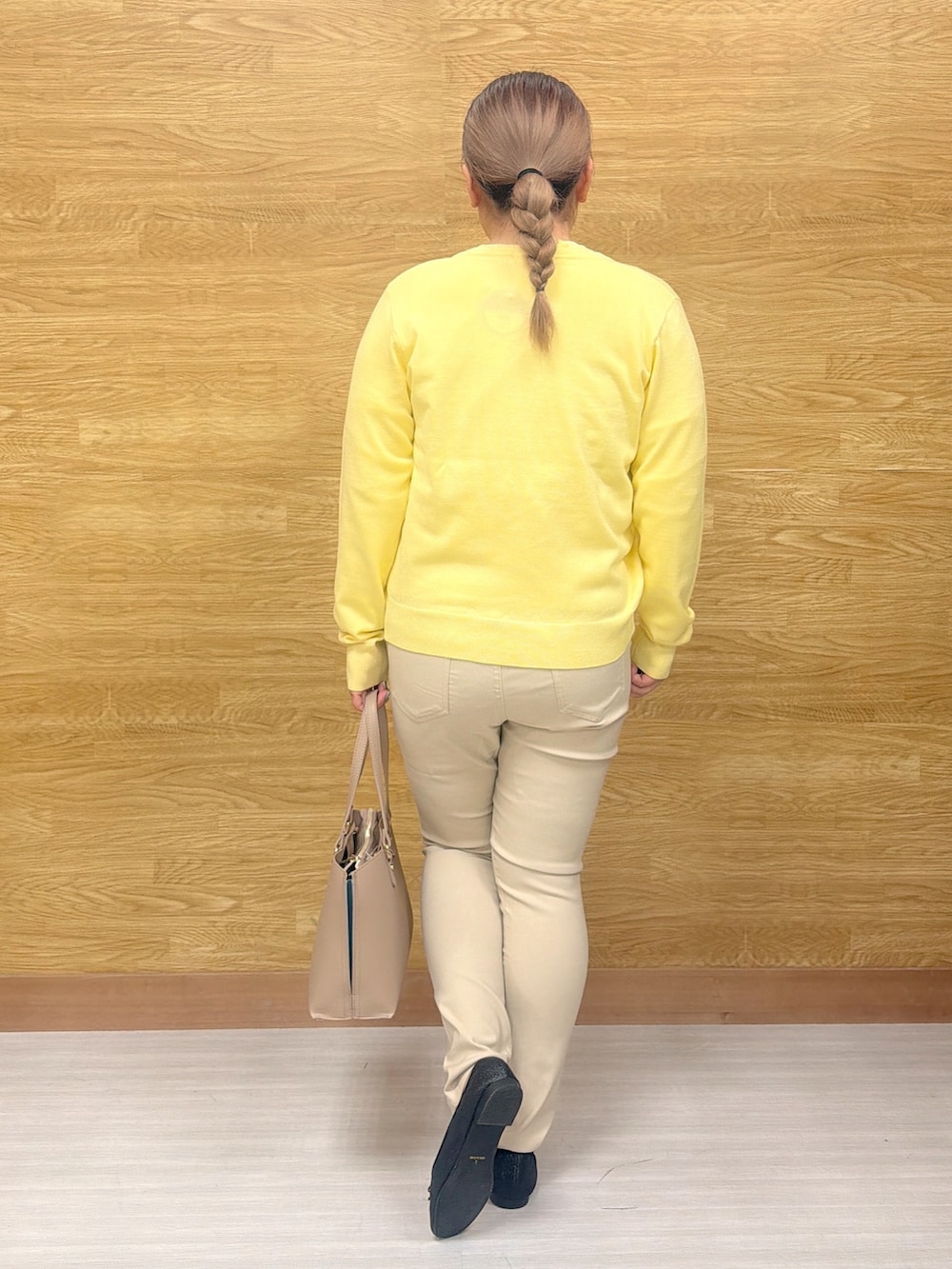 イエロー系のカーディガン/ボレロ、イエロー系のニット/セーター、ベージュ系のその他パンツを着用したレディースの春コーディネートの3枚目の写真