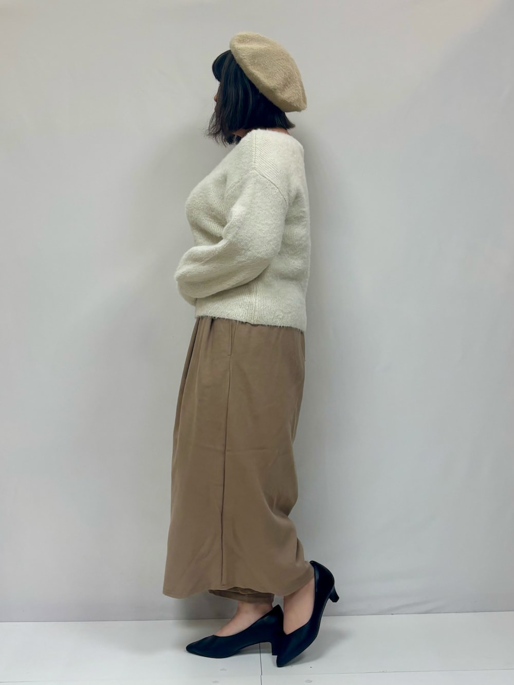 ホワイト系のニット/セーター、ベージュ系のその他パンツ、ブラック系のパンプスを着用したレディースの冬コーディネートの2枚目の写真