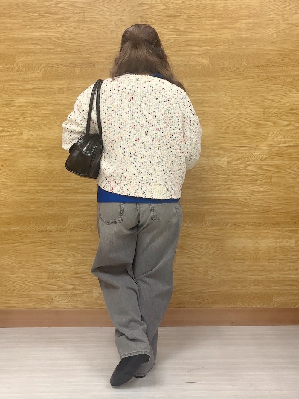 グレー系のデニムパンツ、ホワイト系のカーディガン/ボレロ、ブルー系のニット/セーターを着用したレディースの冬コーディネートの3枚目の写真