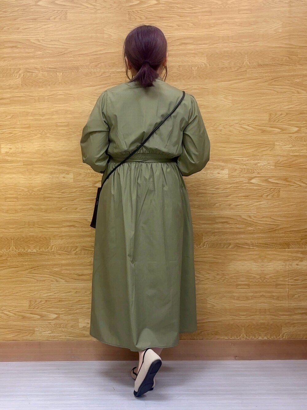 グリーン系のワンピース、ブラック系のパンプス、ブラック系のショルダーバッグを着用したレディースの春コーディネートの3枚目の写真