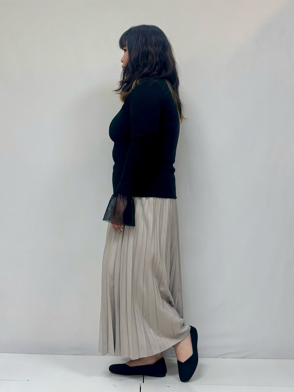 ブラック系のスカート、ブラック系のパンプスを着用したレディースの冬コーディネートの2枚目の写真