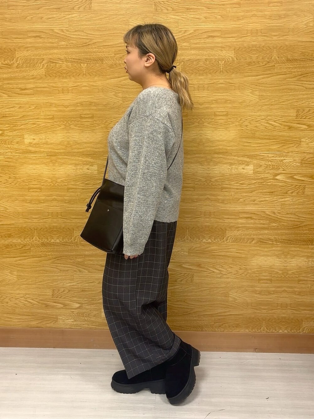 グレー系のニット/セーター、グレー系のその他パンツ、ブラック系のブーツを着用したレディースの冬コーディネートの2枚目の写真