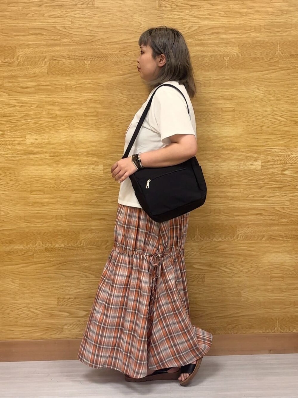 ホワイト系のTシャツ/カットソー、オレンジ系のスカート、ブラック系のサンダルを着用したレディースの夏コーディネートの2枚目の写真