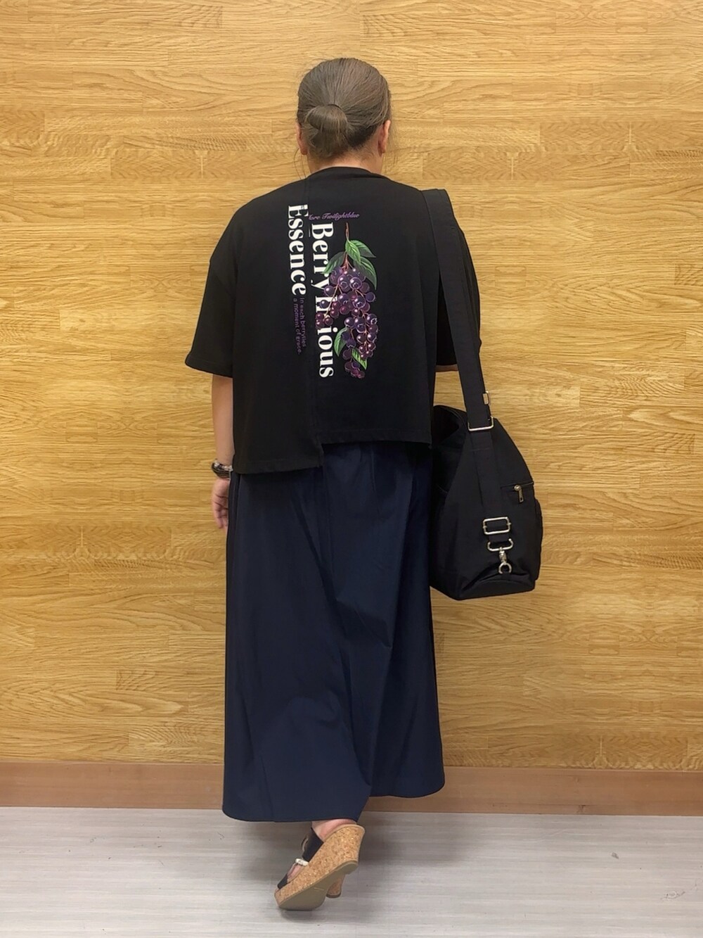 ブルー系のスカート、ブラック系のTシャツ/カットソー、ブラック系のショルダーバッグを着用したレディースの夏コーディネートの2枚目の写真