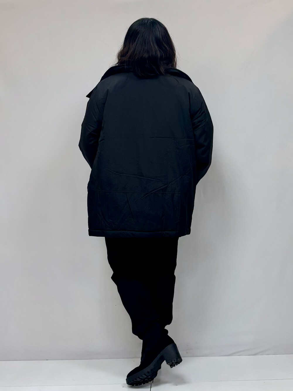 ブラック系のその他パンツ、ブラック系のその他アウター、ブラック系のブーツを着用したレディースの冬コーディネートの2枚目の写真