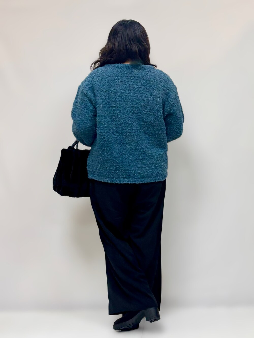 ブラック系のその他パンツ、ブルー系のニット/セーター、ブラック系のブーツを着用したレディースの冬コーディネートの3枚目の写真
