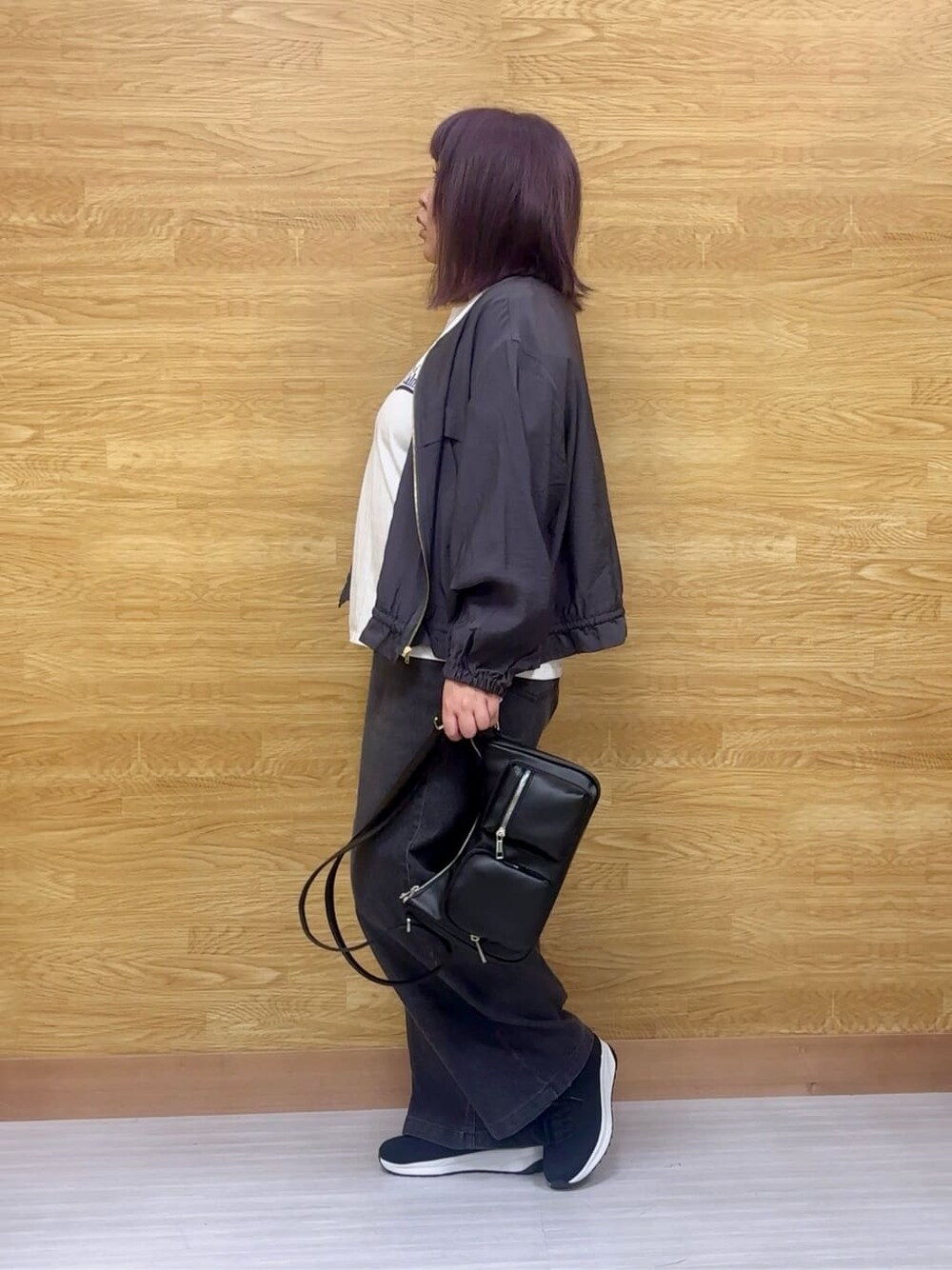グレー系のブルゾン、ホワイト系のTシャツ/カットソー、ブラック系のスニーカーを着用したレディースの春コーディネートの2枚目の写真