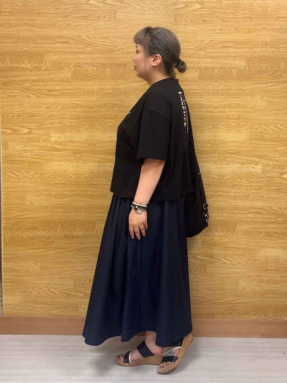 ブラック系のTシャツ/カットソー、ブルー系のスカート、ブラック系のサンダルを着用したレディースの夏コーディネートの2枚目の写真