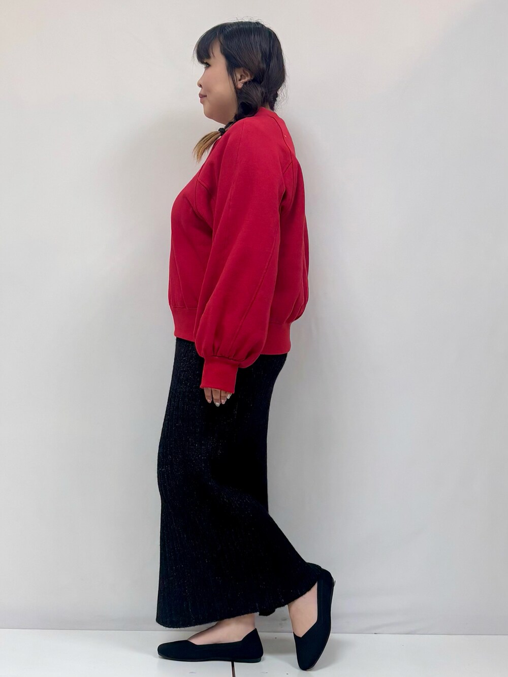 レッド系のTシャツ/カットソー、ブラック系のスカート、ブラック系のパンプスを着用したレディースの冬コーディネートの2枚目の写真