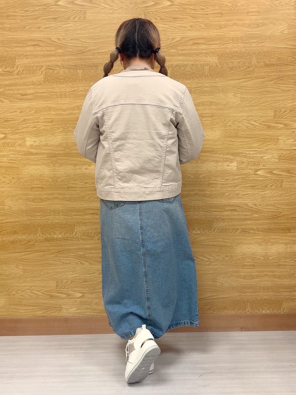 ホワイト系のスニーカー、ブルー系のデニムスカート、ブラウン系のスウェットを着用したレディースの春コーディネートの2枚目の写真