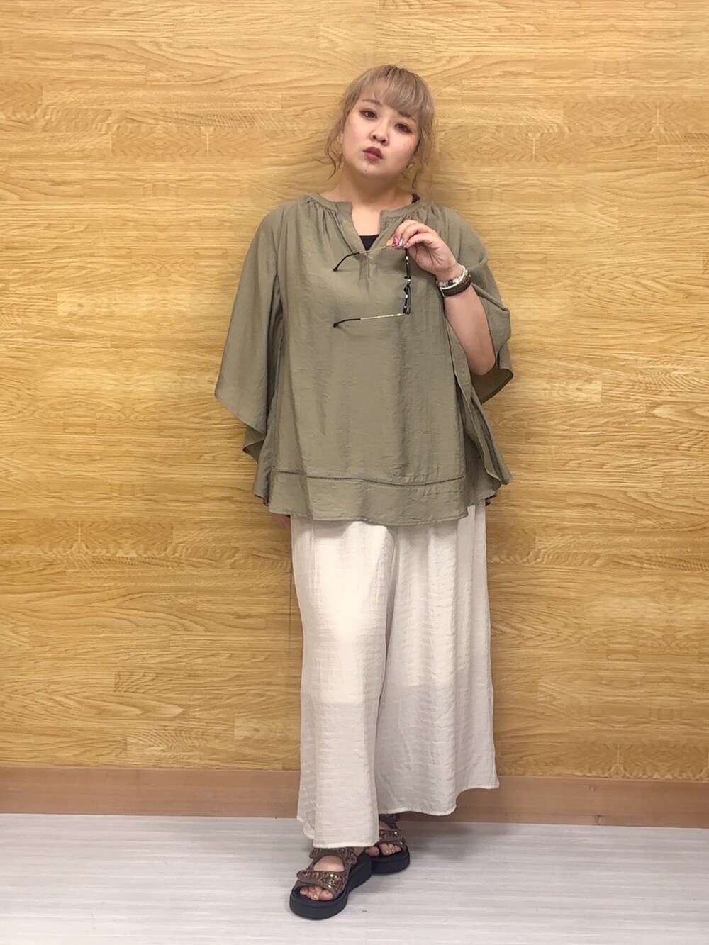 ベージュ系のその他パンツ、その他のサンダル、グリーン系のシャツ/ブラウスを着用したレディースの春コーディネートの2枚目の写真