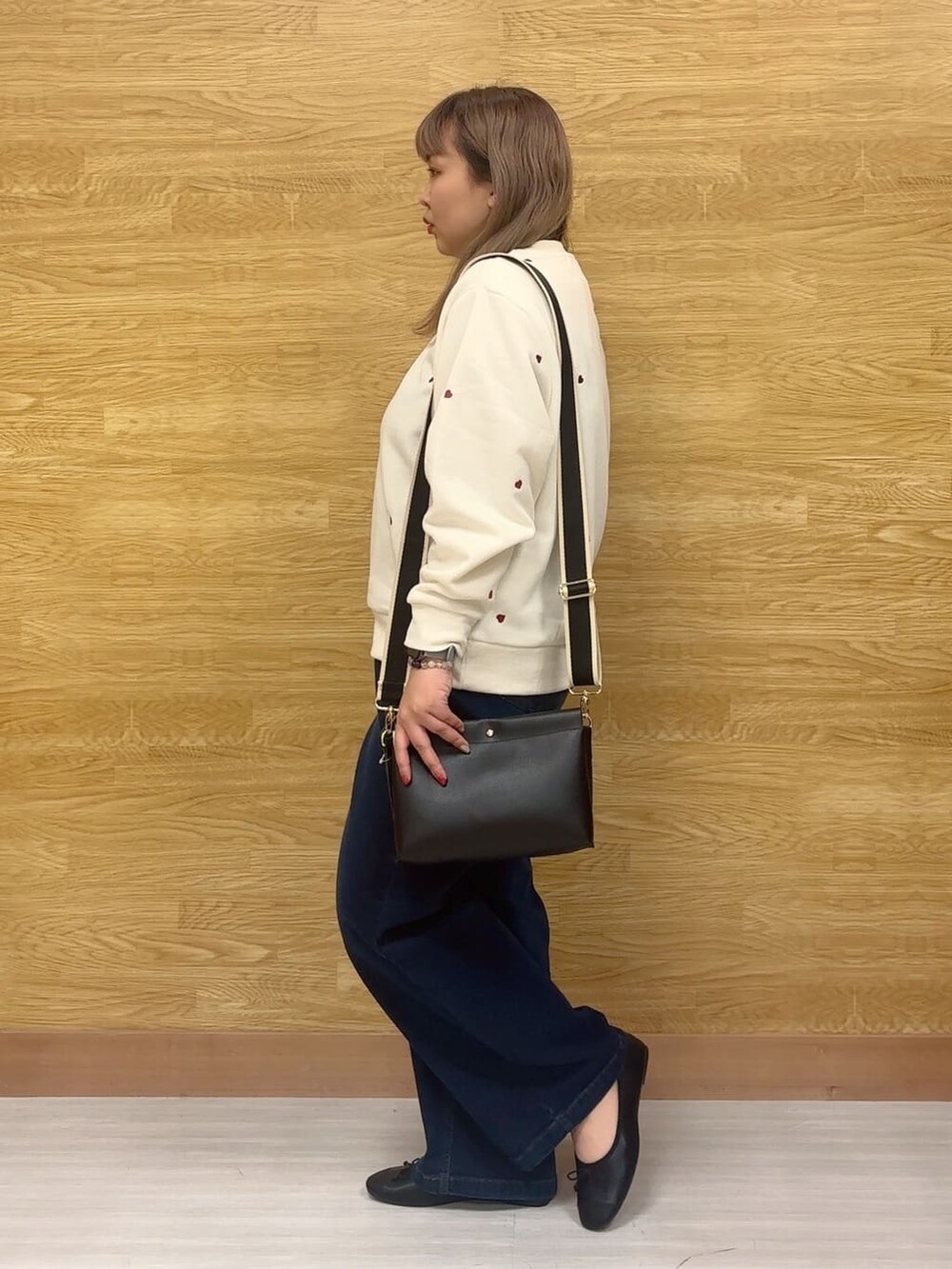 ホワイト系のスウェット、ブルー系のデニムパンツ、ブラック系のその他シューズを着用したレディースの冬コーディネートの2枚目の写真
