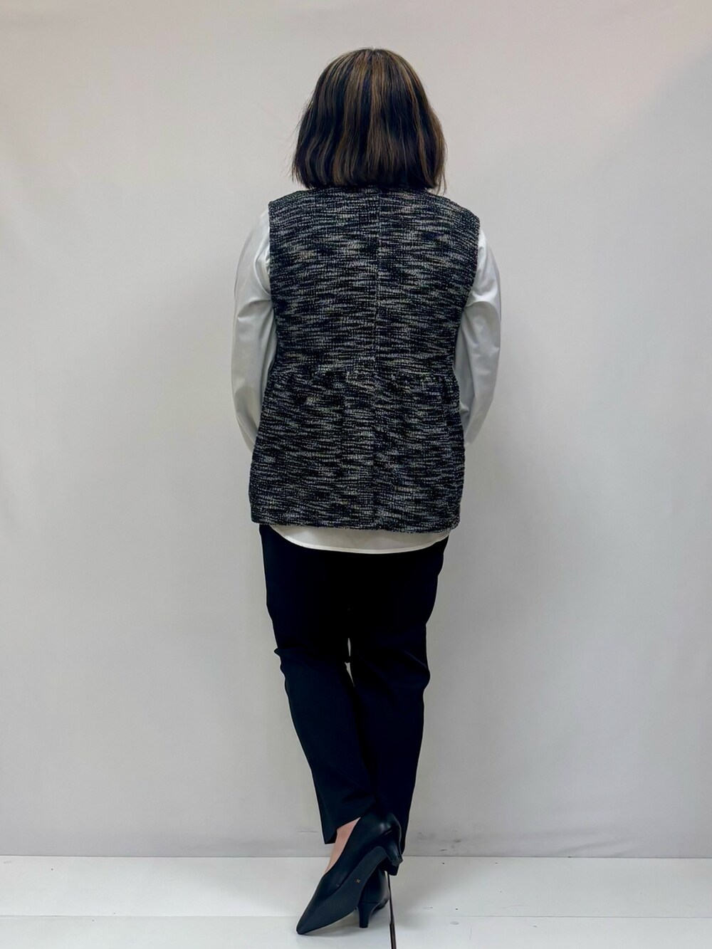ホワイト系のシャツ/ブラウス、ブラック系のベスト、ブラック系のその他パンツを着用したレディースの春コーディネートの3枚目の写真