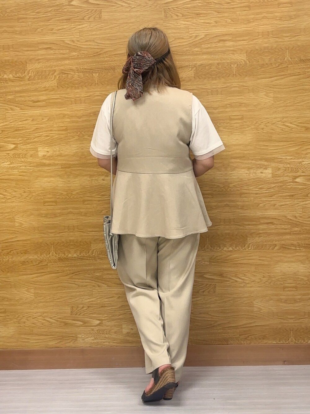 ホワイト系のベスト、ベージュ系のその他パンツを着用したレディースの春コーディネートの2枚目の写真