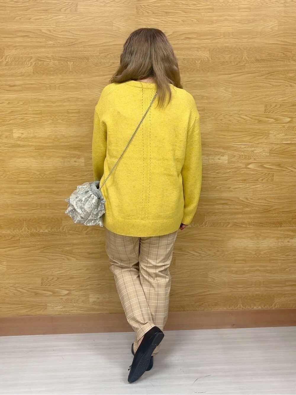 イエロー系のニット/セーター、ベージュ系のその他パンツ、ブラック系のその他シューズを着用したレディースの冬コーディネートの3枚目の写真