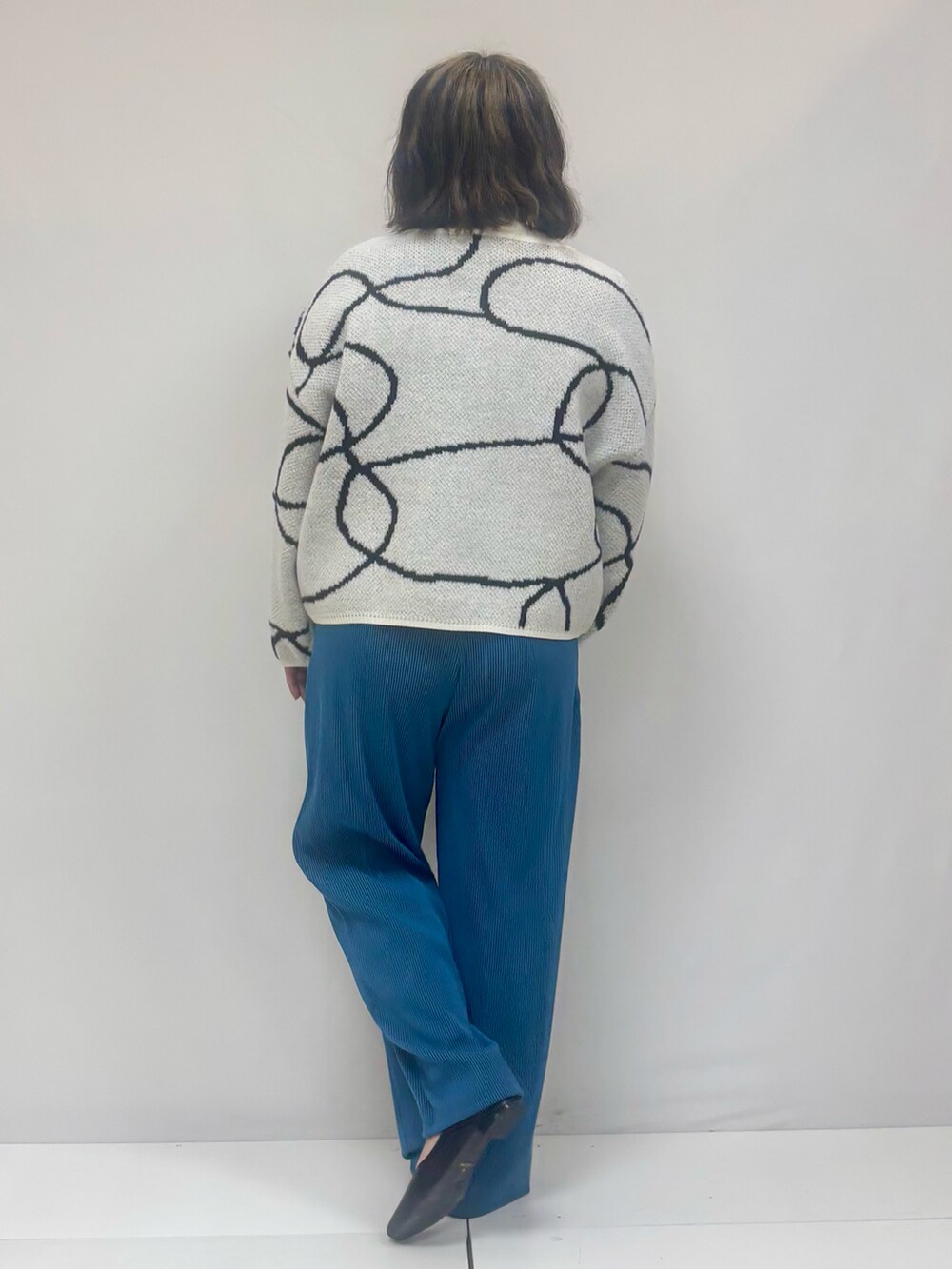 ホワイト系のカーディガン/ボレロ、ブラック系のパンツ、ブラック系のその他シューズを着用したレディースの冬コーディネートの3枚目の写真