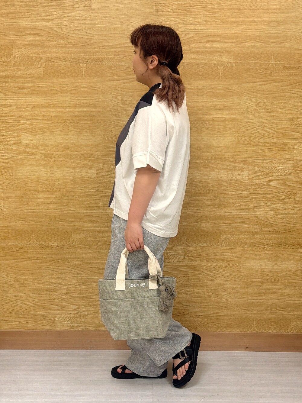 ブラック系のTシャツ/カットソー、グレー系のその他パンツ、グレー系のトートバッグを着用したレディースの春コーディネートの2枚目の写真