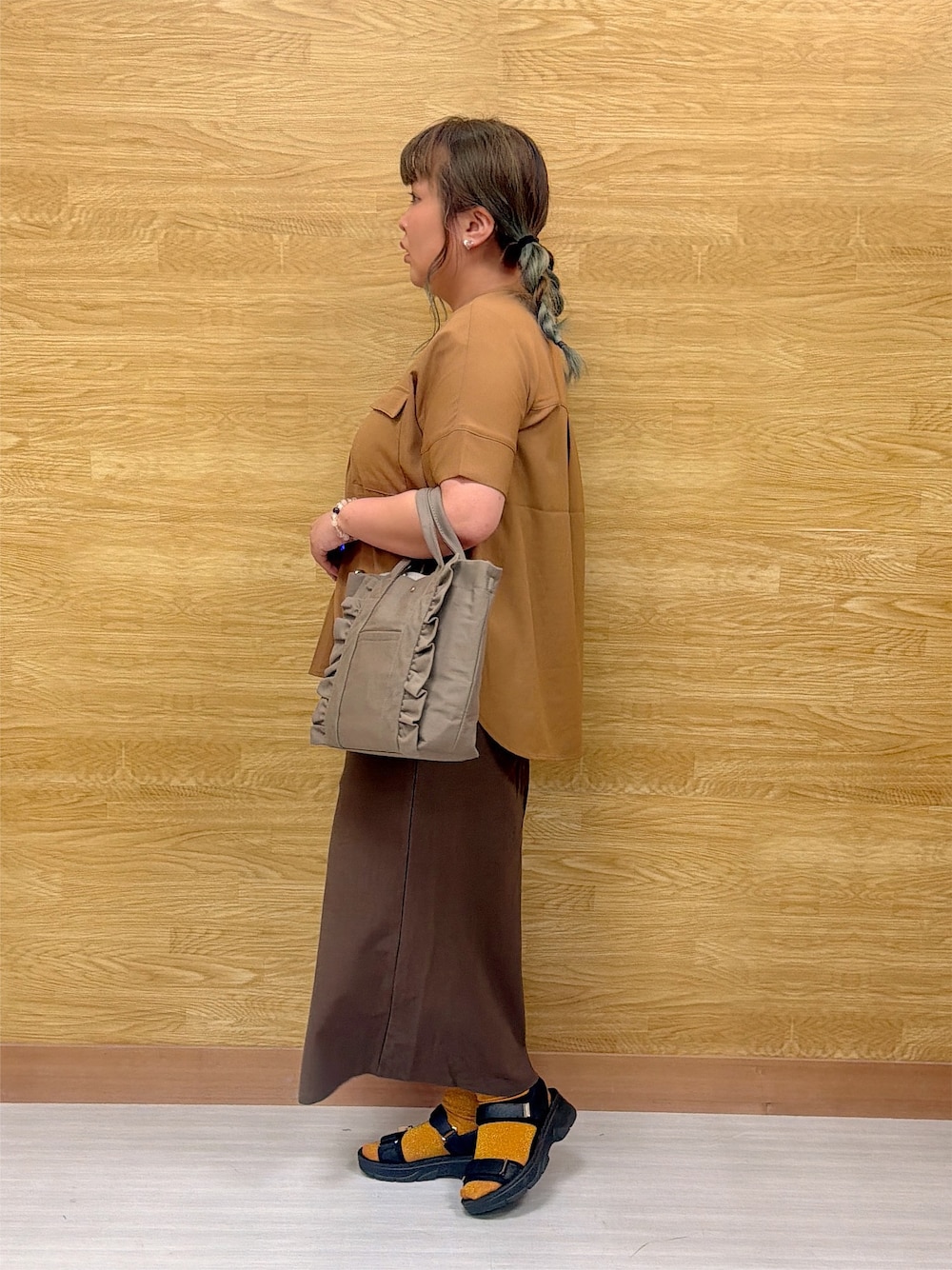 イエロー系のシャツ/ブラウス、ブラウン系のスカート、グレー系のトートバッグを着用したレディースの夏コーディネートの2枚目の写真