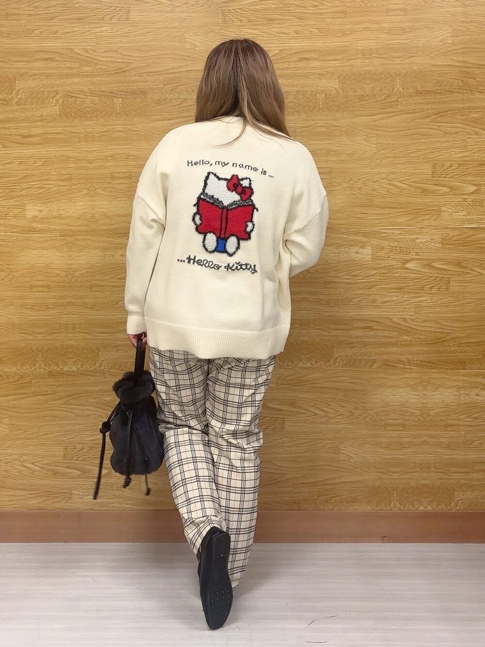 ホワイト系のカーディガン/ボレロ、イエロー系のニット/セーター、グレー系のその他パンツを着用したレディースの冬コーディネートの3枚目の写真