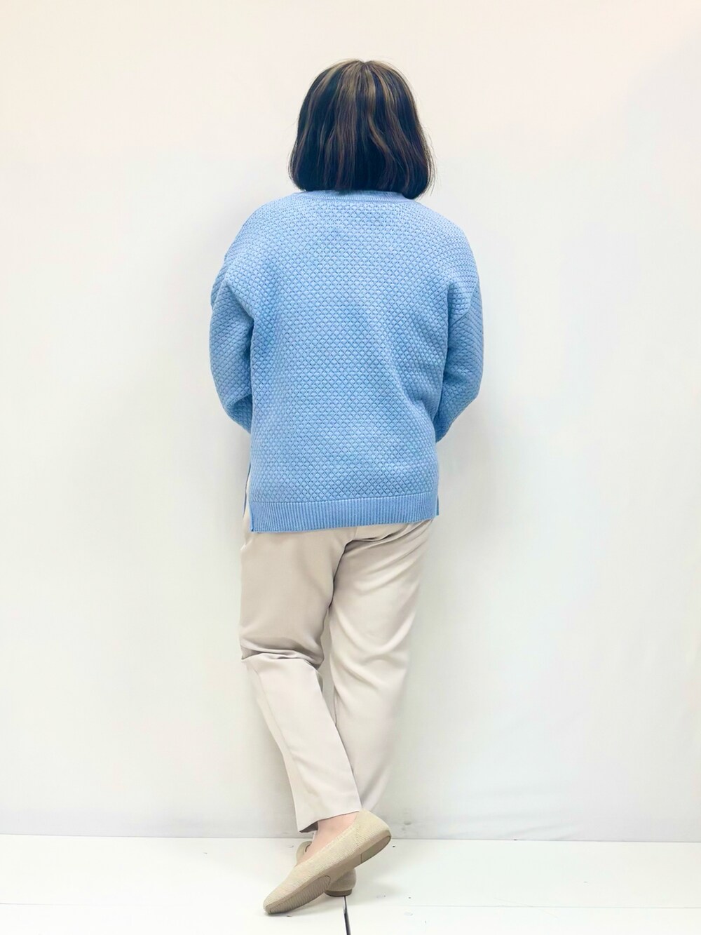 ブルー系のニット/セーター、ブラウン系のその他パンツ、ブラック系のパンプスを着用したレディースの冬コーディネートの3枚目の写真