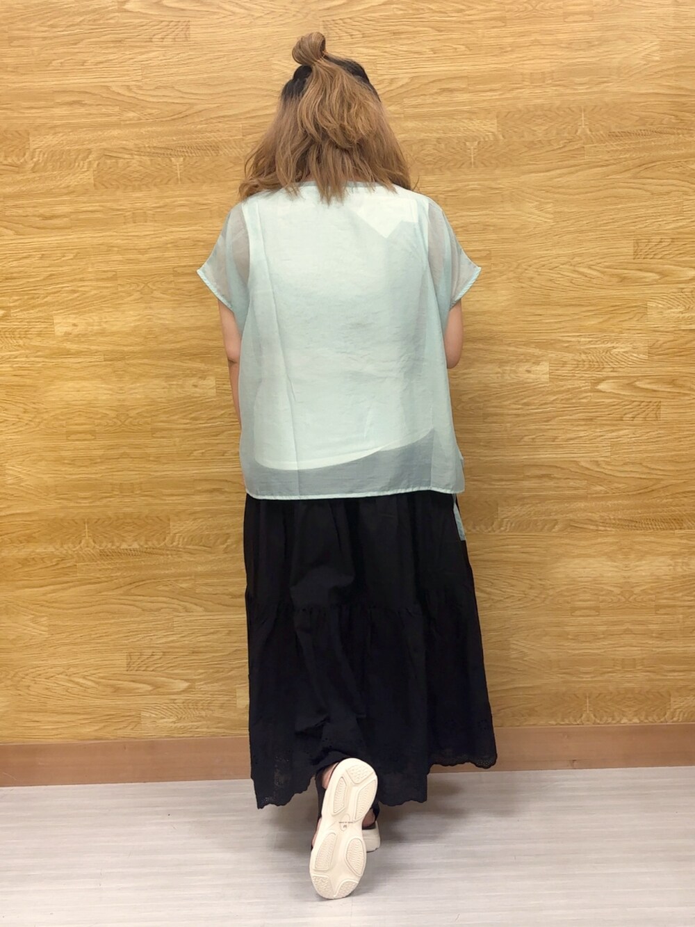 ブラック系のスカートを着用したレディースの秋コーディネートの2枚目の写真