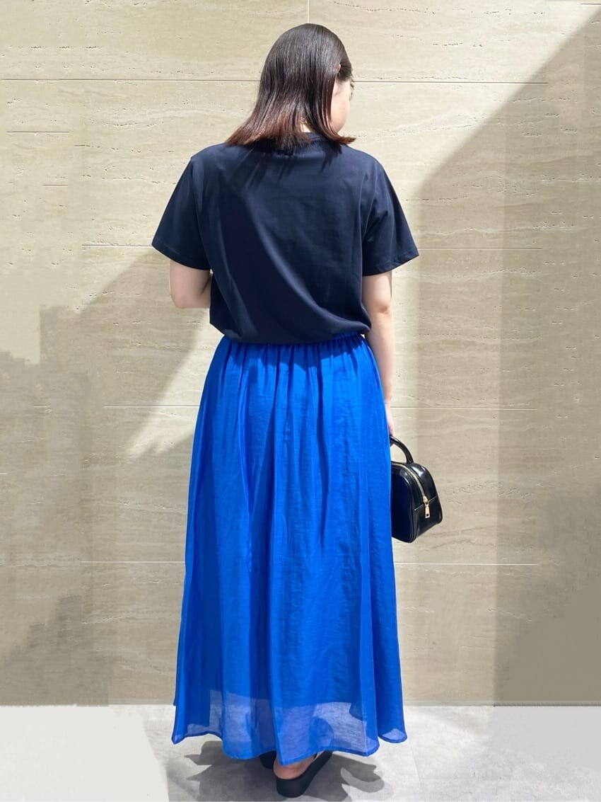 ブルー系のTシャツ/カットソー、ブルー系のスカート、ブラック系のショルダーバッグを着用したレディースの夏コーディネートの2枚目の写真