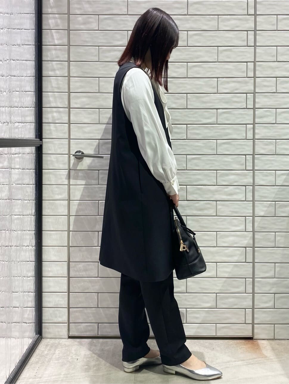 ブラック系のベスト、ホワイト系のシャツ/ブラウス、ブラック系のその他パンツを着用したレディースの冬コーディネートの3枚目の写真