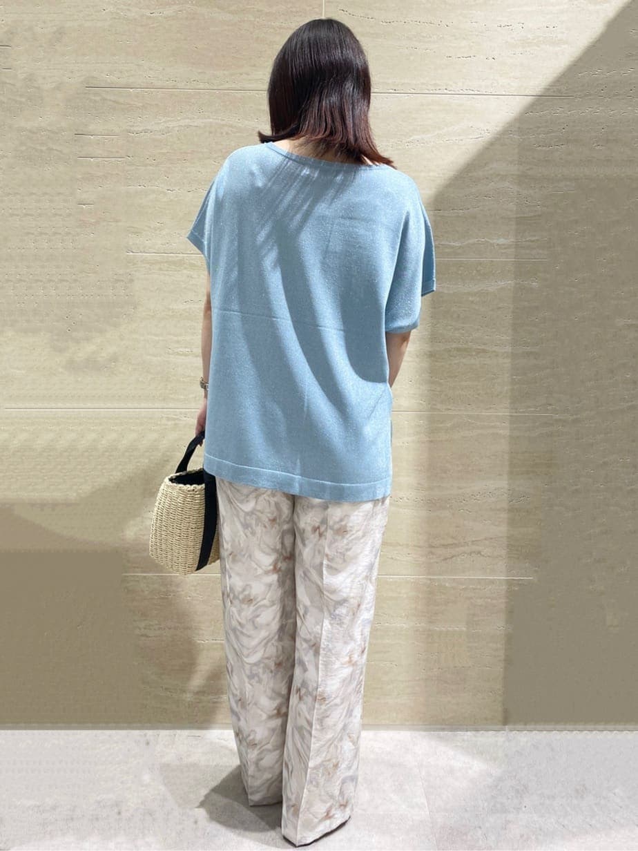 ブルー系のニット/セーター、グレー系のその他パンツ、ブラック系のショルダーバッグを着用したレディースの春コーディネートの2枚目の写真